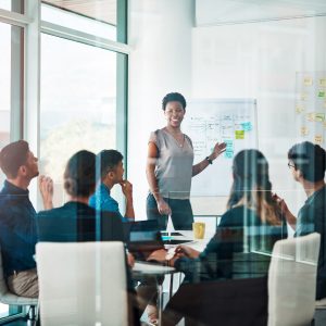 woman presenting in front of whiteboard in conference room