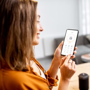 woman smiling at security app on mobile phone