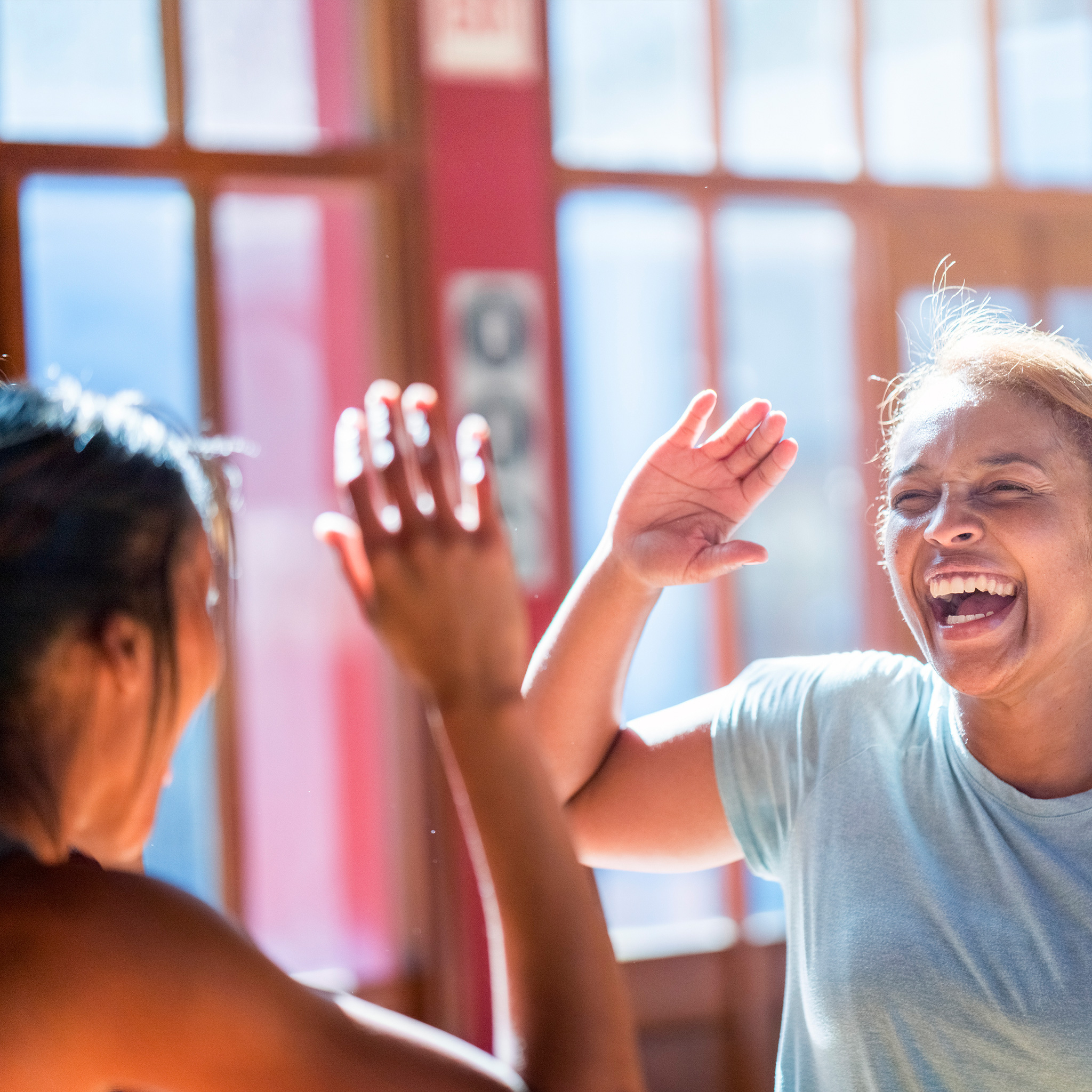 two women high-fiving after workout