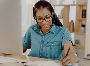 young businesswoman wearing headset and working on a computer at home