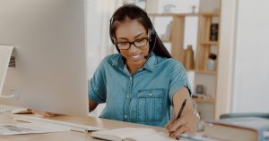 young businesswoman wearing headset and working on a computer at home