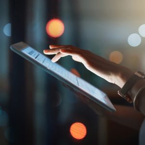 businesswoman using a digital tablet while working late