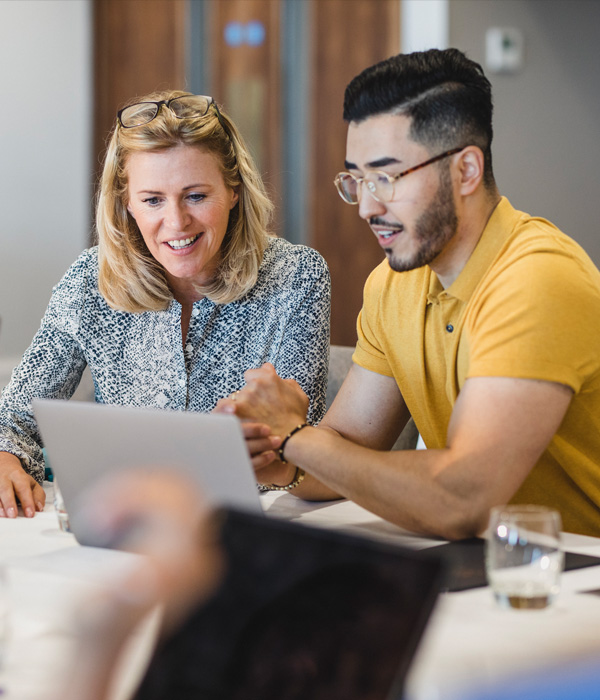 two coworkers sitting in front of laptop
