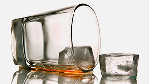 glass with ice and alcohol tipped over