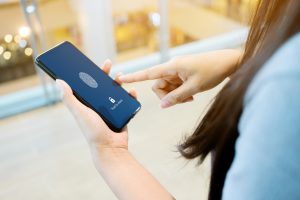 woman unlocking phone with scan fingerprint biometric identity