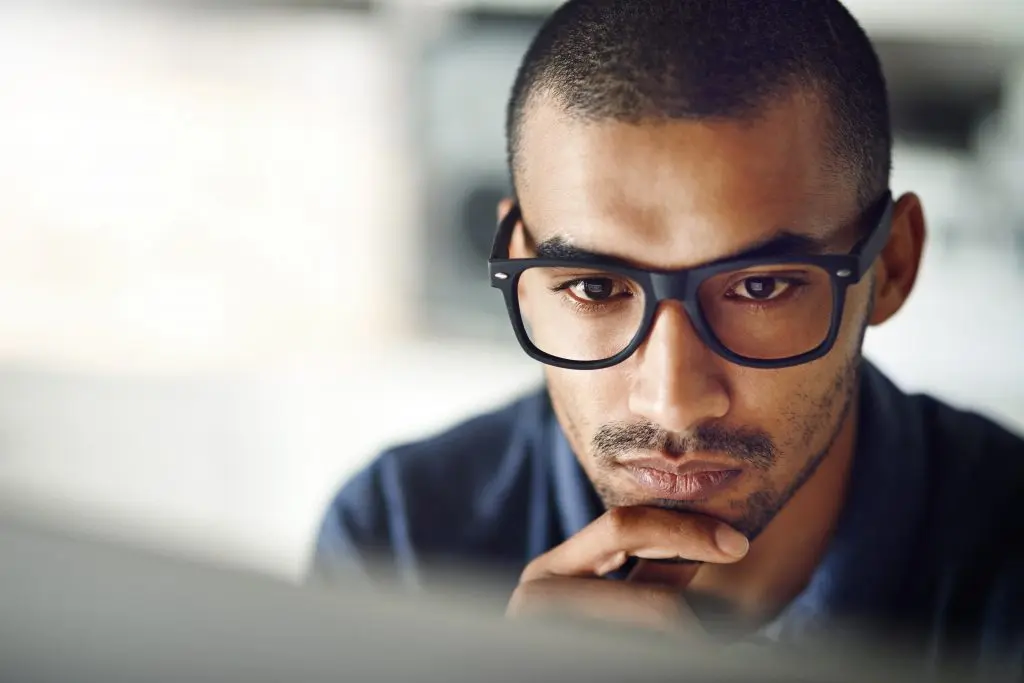 businessman with glasses using his computer in his home office