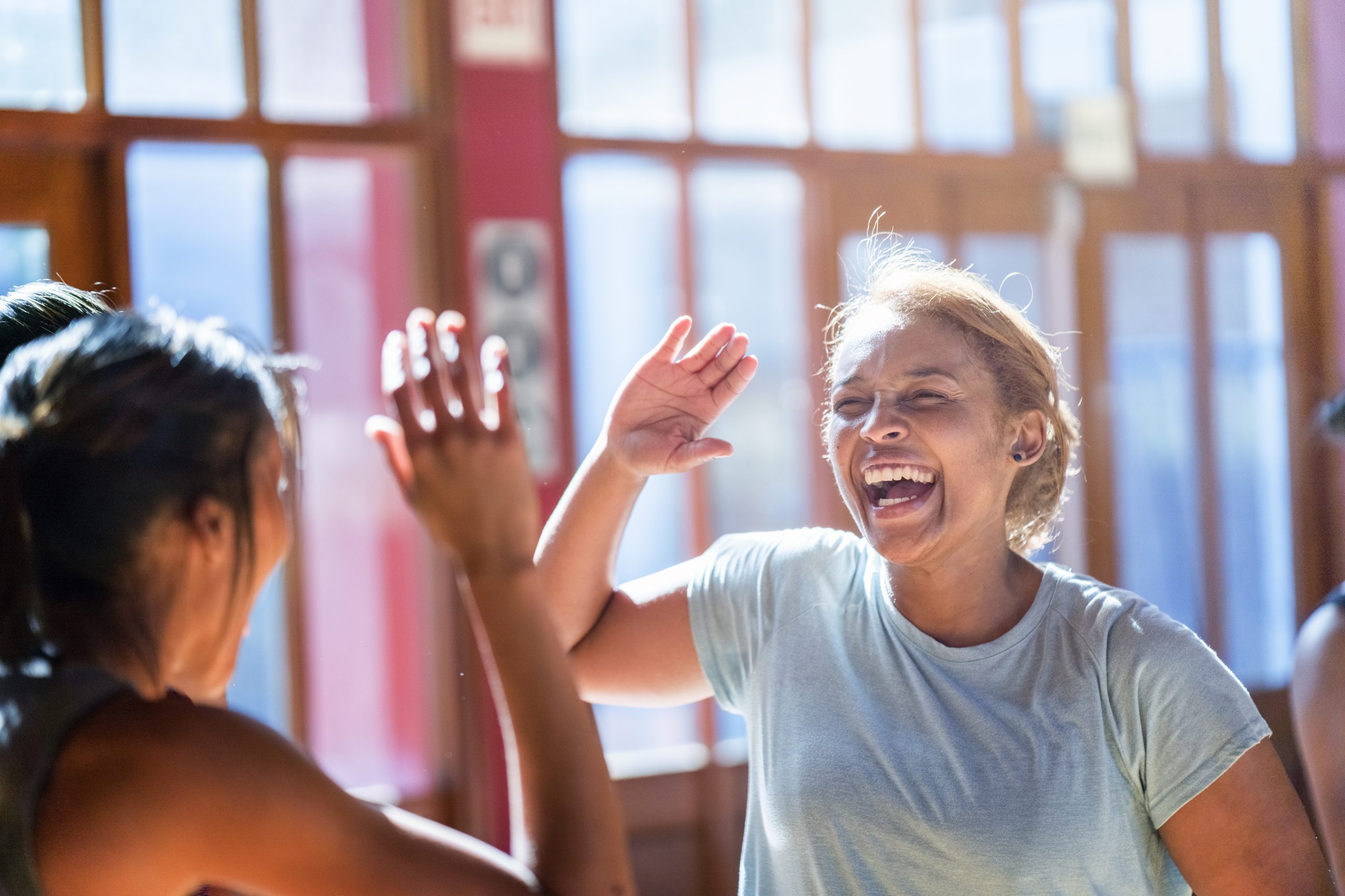 two women high-fiving after workout