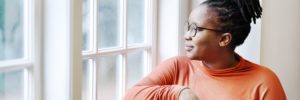 Woman in glasses looking out the window