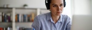 Woman in headphones doing work on a laptop