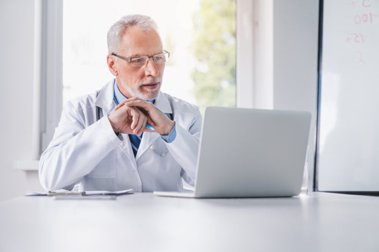 Doctor reviewing patient engagement data on laptop