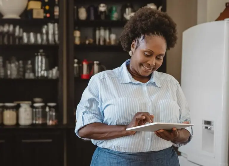 A woman looking down at a tablet while working.