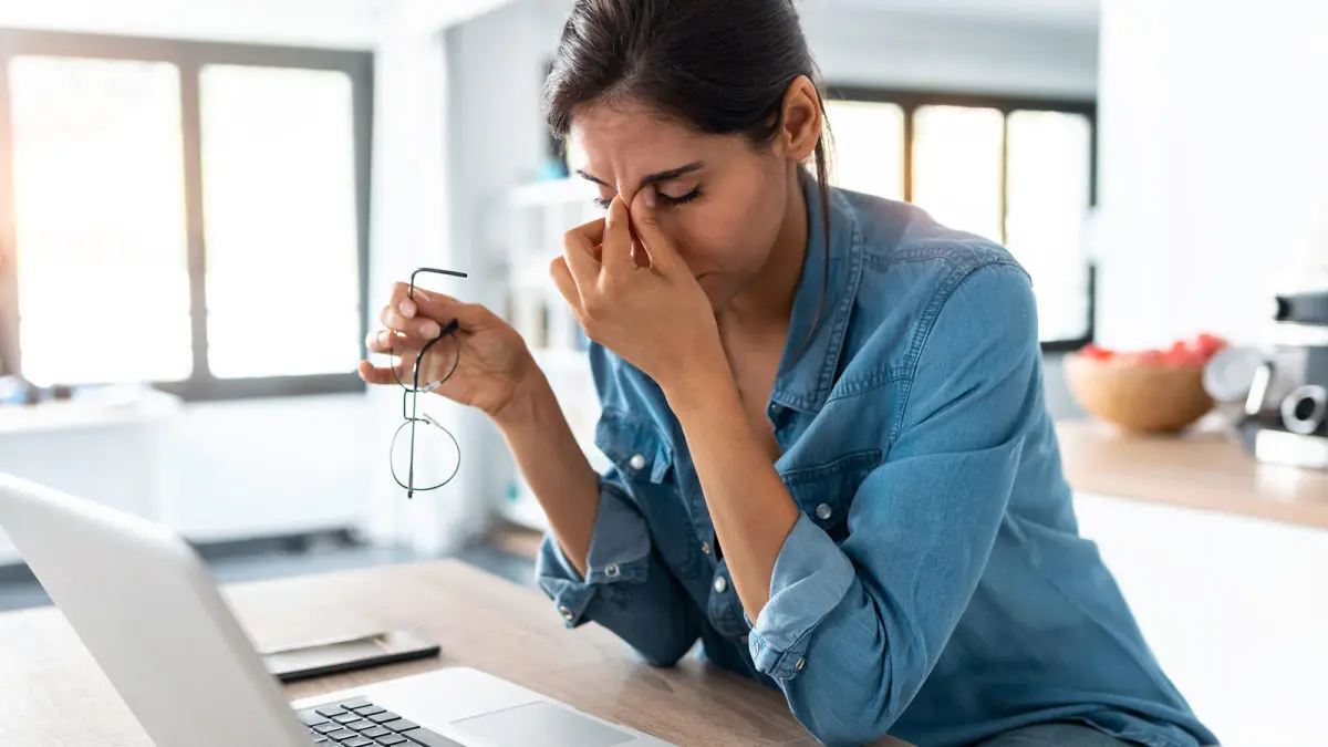 Stressed professional working from home, highlighting need for employee wellness