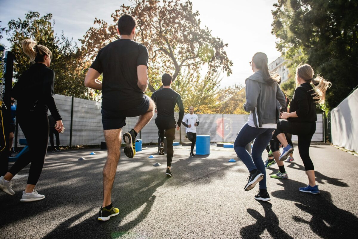 Employees participating in an outdoor group fitness session as part of a corporate wellness coaching program
