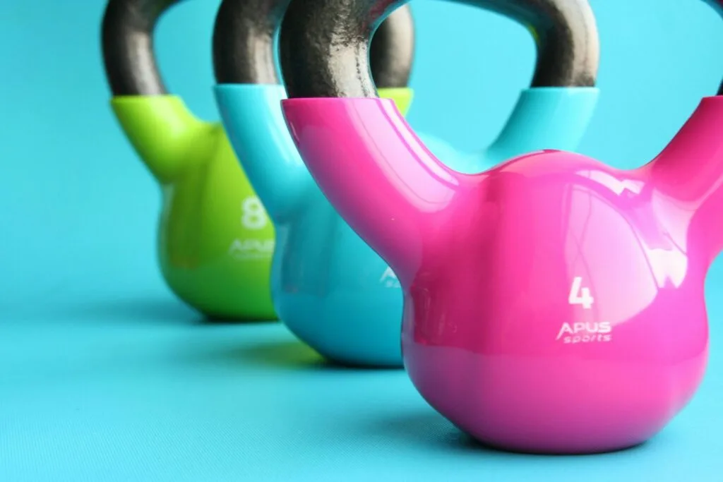 Colorful kettlebells lined up on a gym floor, representing strength training for muscle preservation during GLP-1 medication use.