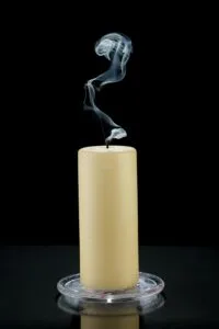 Extinguished candle releasing a thin trail of smoke, symbolizing burnout and mental exhaustion in the workplace