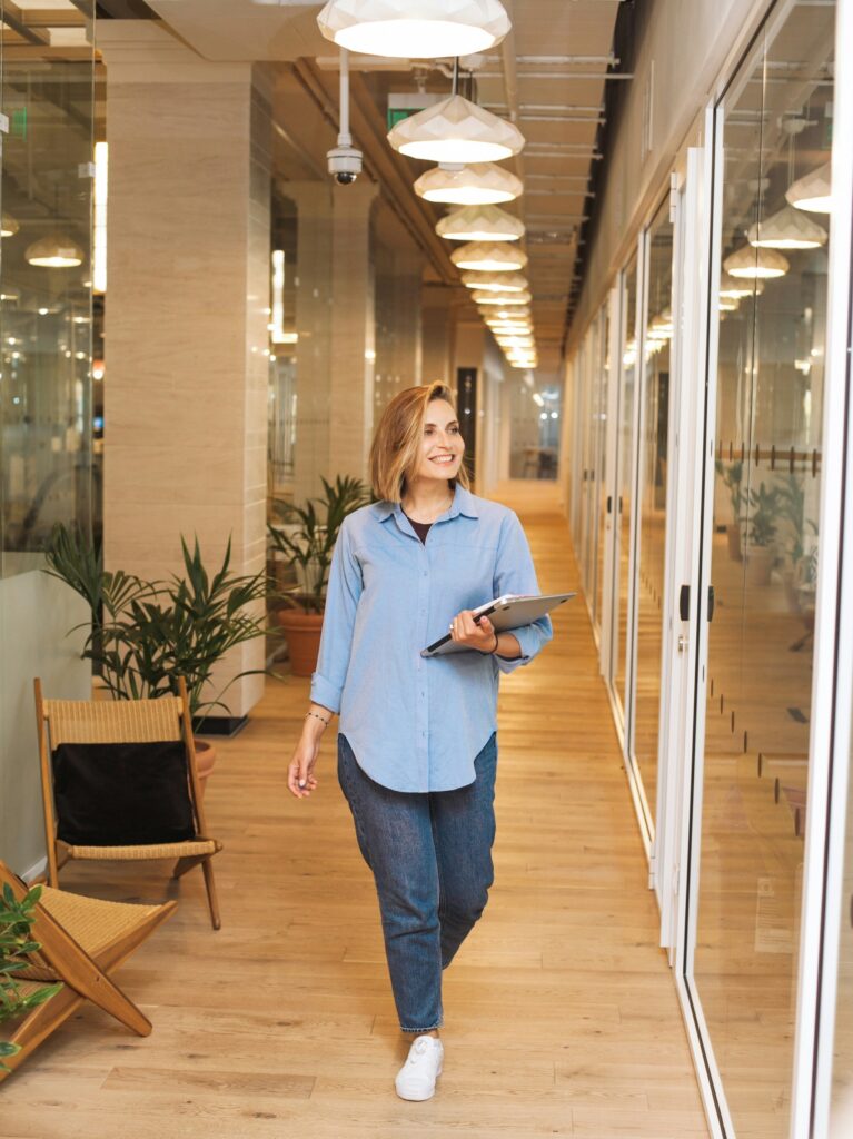 Employee walking through office with tablet, representing forward momentum in wellness programs