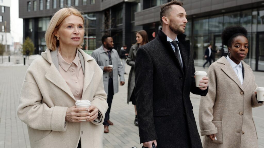 How To Host Walking Meetings: Strategies To Energize Your Team 3 A diverse group of professionals walking outdoors in conversation, illustrating informal team engagement through walking meetings.