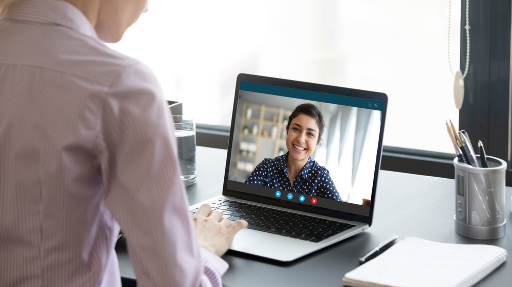A woman participates in a virtual coaching session, highlighting the role of behavior change for health through digital wellness support.