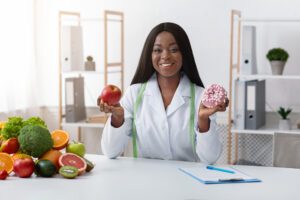 Health professional demonstrating healthy choice versus junk food to support employee wellness programs.