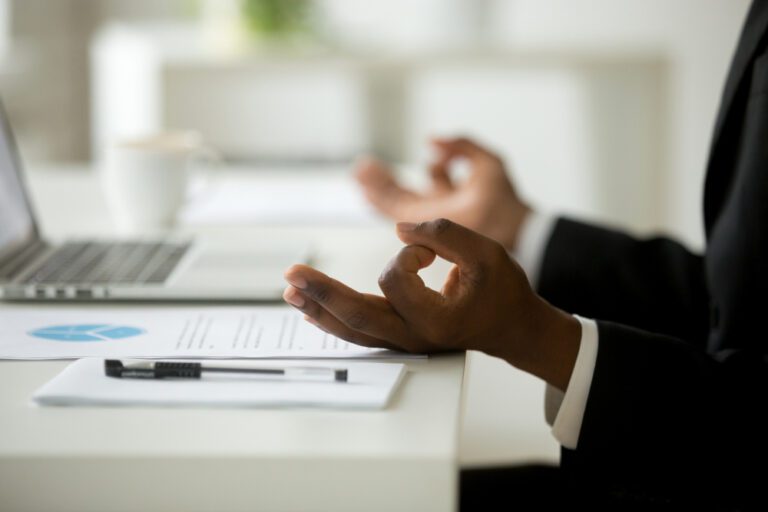 Business professional pausing at a desk during the workday, reflecting on healthier habits at work