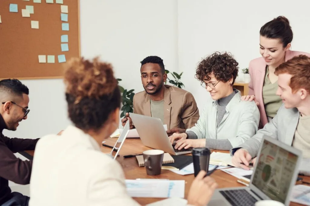 Small business employees meeting in a collaborative office environment discussing workplace initiatives.