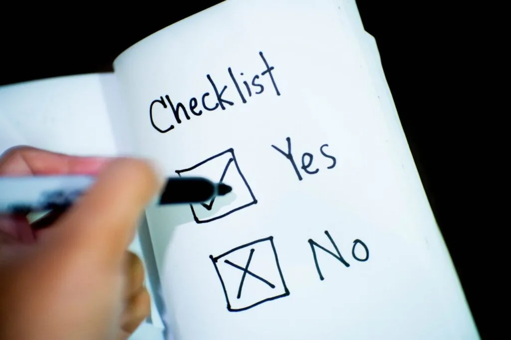 Hand checking a yes box on a checklist in a notebook