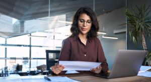 HR director reviewing employee health benefits documents at her desk