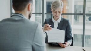 HR professional reviewing GLP-1 health plan documents with employee in office meeting