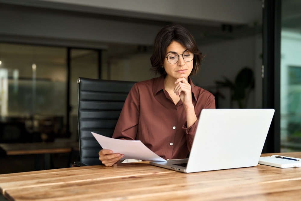 HR professional reviewing employee wellness resources at her desk