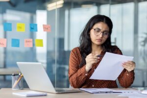 HR manager reviewing employee healthcare cost documents at her desk