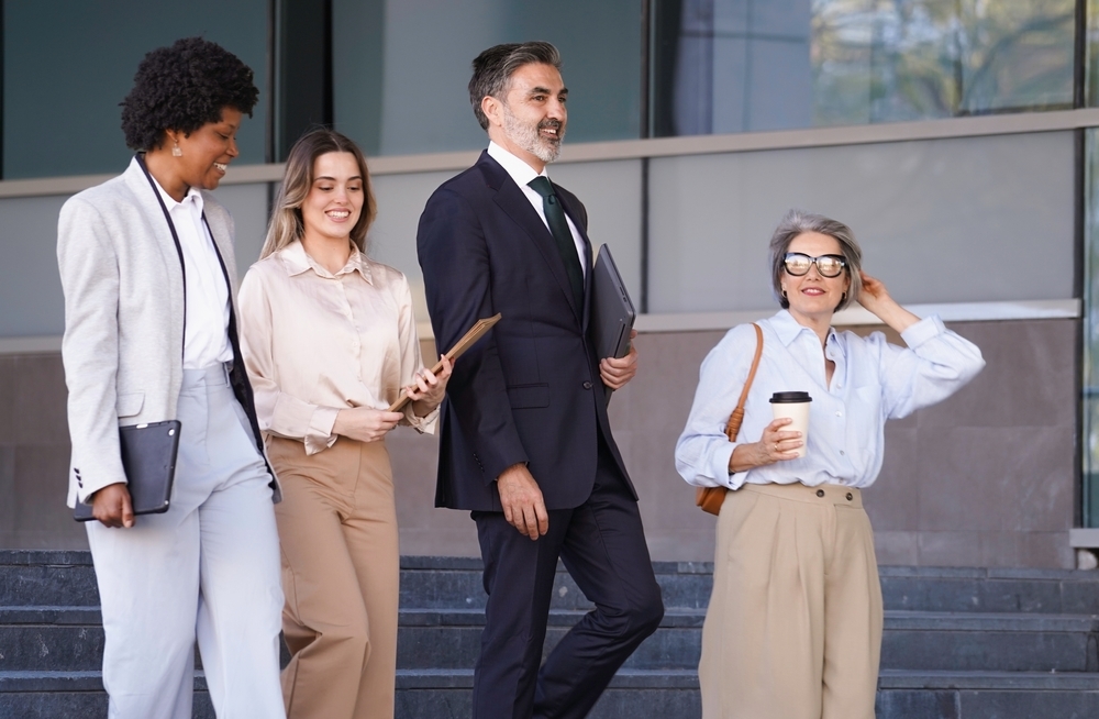 Employees doing a walking meeting outdoors as a creative employee wellness program idea
