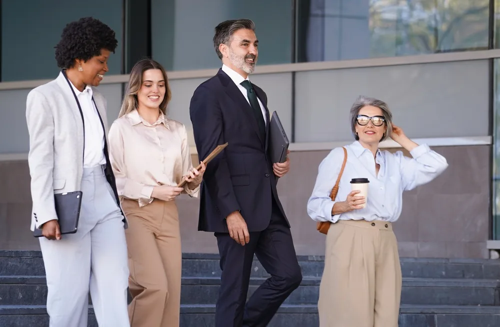 Diverse team of employees walking outside together during a walking meeting