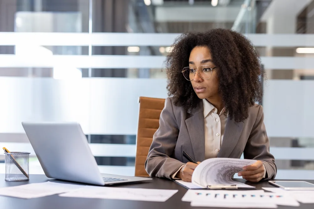 HR leader reviewing employee wellness documents at office desk
