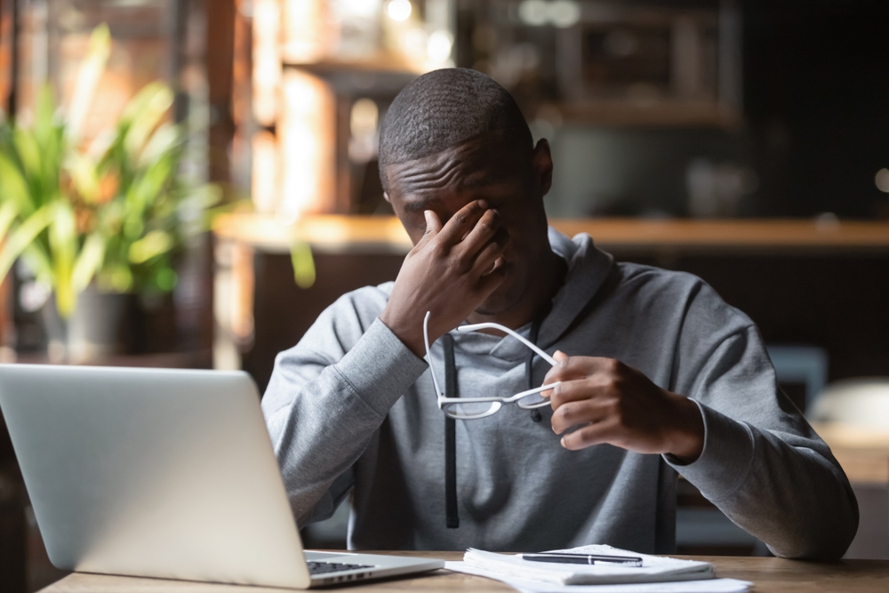 Employee experiencing stress and mental health strain alongside musculoskeletal pain