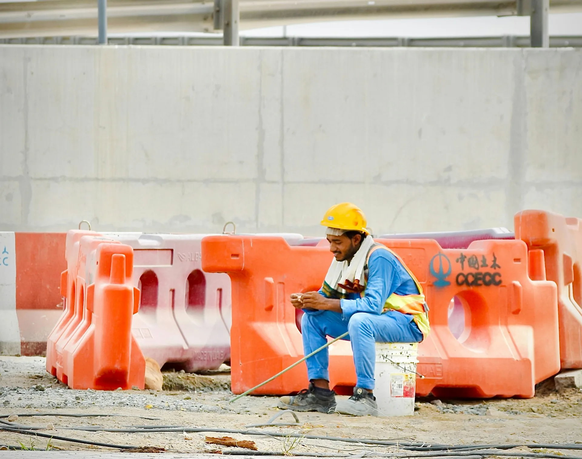 Frontline construction worker in a hard hat taking a short break on a job site