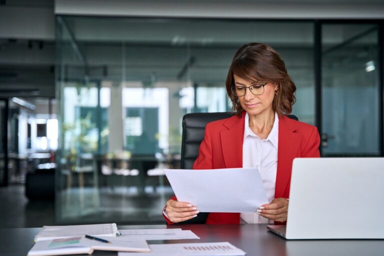Care manager reviewing a member caseload list at her desk with a laptop