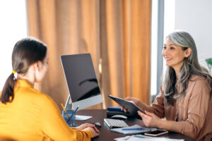 Care team lead reviewing member caseloads with a colleague at a workstation