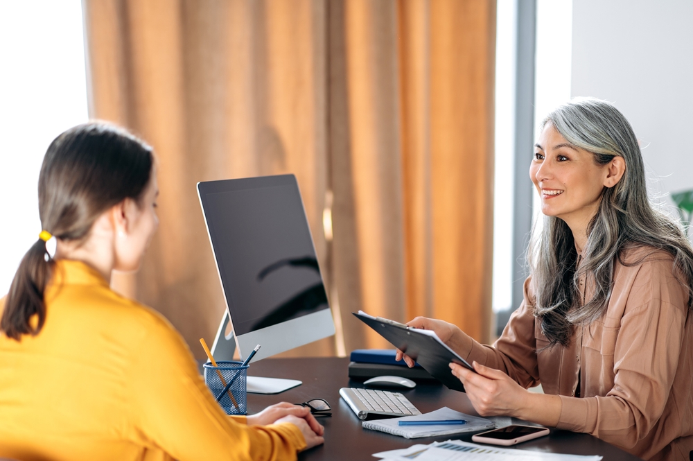 Care team lead reviewing member caseloads with a colleague at a workstation