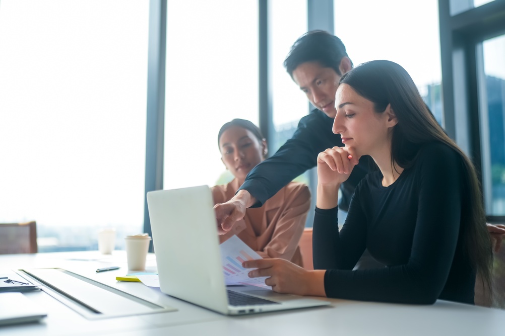Coaching program leaders weighing platform options against cost data in a conference room