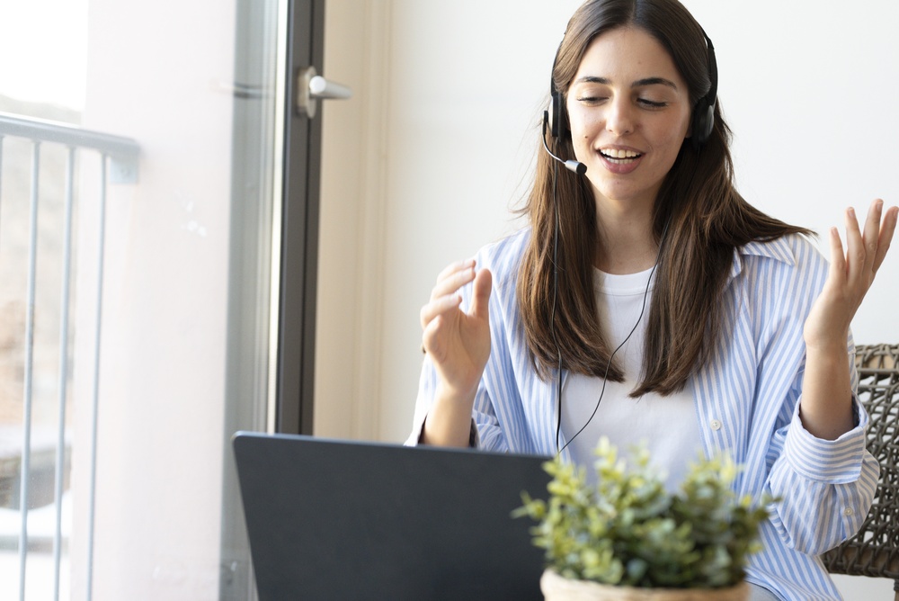 Health coach wearing a headset leading a virtual coaching session on a laptop