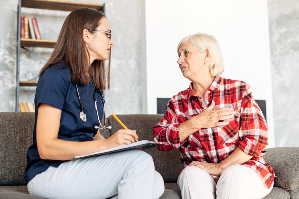 Depression screening follow-up for Medicare members Nurse listening to an older woman during a home visit as part of depression screening follow-up
