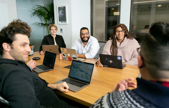 Diverse team meeting, supporting workplace wellness and inclusion A diverse team collaborating in a modern office—key to an inclusive employee wellness program.
