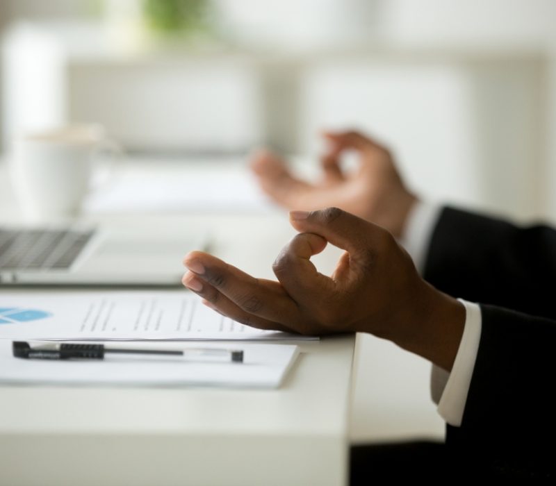 Business professional pausing at a desk during the workday, reflecting on healthier habits at work